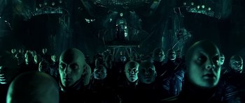 Movie still from “Dark City” (1998), directed by Alex Proyas – A group of people in a dark room with lights on them; Wide shot, Low angle