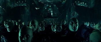 Movie still from “Dark City” (1998), directed by Alex Proyas – A group of people in a dark room; Wide shot, Low angle