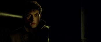 Movie still from “Dark City” (1998), directed by Alex Proyas – A man in a dark room with his head turned to the side; Close Up shot, High angle