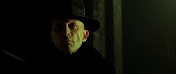 Movie still from “Dark City” (1998), directed by Alex Proyas – A person wearing a hat; Close Up shot, Low angle