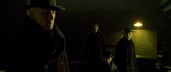 Movie still from “Dark City” (1998), directed by Alex Proyas – A group of people standing next to each other in the dark; Close Up shot, Low angle