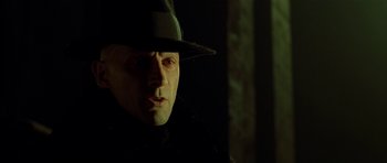 Movie still from “Dark City” (1998), directed by Alex Proyas – A person wearing a hat; Close Up shot, Low angle