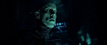 Movie still from “Dark City” (1998), directed by Alex Proyas – A person wearing a suit and tie; Close Up shot, Low angle