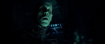 Movie still from “Dark City” (1998), directed by Alex Proyas – A person wearing a suit and tie; Close Up shot, Low angle