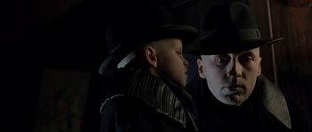 Movie still from “Dark City” (1998), directed by Alex Proyas – A young boy wearing a hat and a black coat; Close Up shot, Low angle