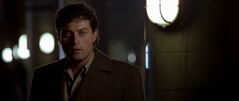 Movie still from “Dark City” (1998), directed by Alex Proyas – A person wearing a suit and tie; Close Up shot, Low angle