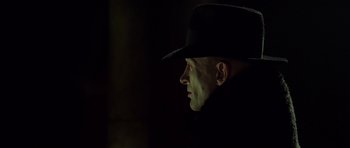 Movie still from “Dark City” (1998), directed by Alex Proyas – A man wearing a black hat and a black jacket; Close Up shot, Low angle