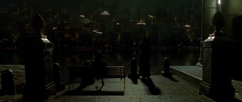 Movie still from “Dark City” (1998), directed by Alex Proyas – Two people are sitting on a bench in the dark; Extreme Wide shot, High angle
