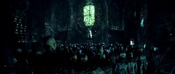 Movie still from “Dark City” (1998), directed by Alex Proyas – A large group of people in a dark room; Wide shot, Low angle