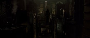 Movie still from “Dark City” (1998), directed by Alex Proyas – A man standing in the dark in a dark room; Extreme Wide shot, High angle