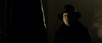 Movie still from “Dark City” (1998), directed by Alex Proyas – A man wearing a black hat and a black coat; Close Up shot, Low angle