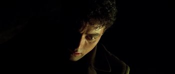 Movie still from “Dark City” (1998), directed by Alex Proyas – A person wearing a black jacket; Close Up shot, High angle