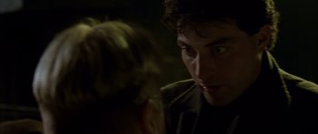 Movie still from “Dark City” (1998), directed by Alex Proyas – A man looking at another man in a dark room; Close Up shot, Over the shoulder angle