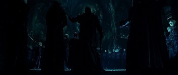Movie still from “Dark City” (1998), directed by Alex Proyas – A group of people standing in a dark room; Wide shot, Low angle