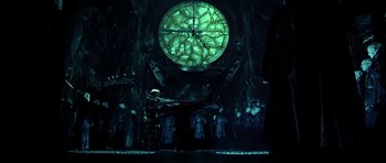 Movie still from “Dark City” (1998), directed by Alex Proyas – A group of people standing in front of a large clock; Wide shot, Low angle