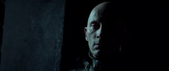 Movie still from “Dark City” (1998), directed by Alex Proyas – A man with bald head wearing a leather jacket; Close Up shot, Low angle