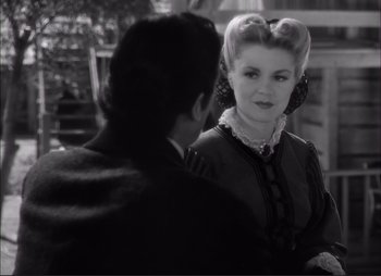 Movie still from “Dark Command” (1940), directed by Raoul Walsh – An old fashioned woman and a young man in a black and white photo; Close Up shot, Over the shoulder angle