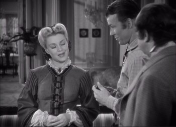 Movie still from “Dark Command” (1940), directed by Raoul Walsh – A man and a woman are talking to another man in a room; Medium shot, Over the shoulder angle