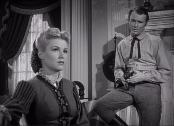 Movie still from “Dark Command” (1940), directed by Raoul Walsh – A man and a woman sitting on a chair; Medium shot, Low angle