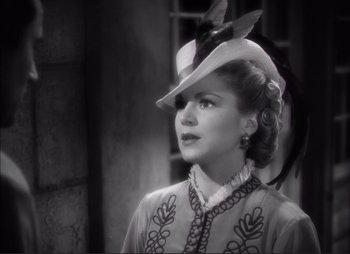 Movie still from “Dark Command” (1940), directed by Raoul Walsh – A black and white photo of a woman wearing a hat; Close Up shot, Over the shoulder angle