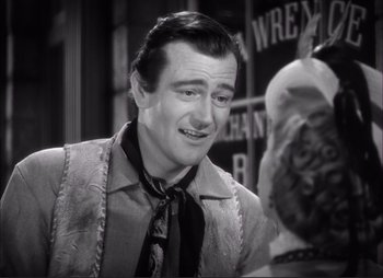 Movie still from “Dark Command” (1940), directed by Raoul Walsh – A black and white photo of a man talking to a woman; Close Up shot, Over the shoulder angle