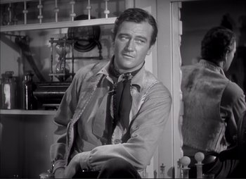 Movie still from “Dark Command” (1940), directed by Raoul Walsh – A black and white photo of a man wearing a tie; Medium shot, Over the shoulder angle