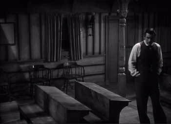 A man standing next to two benches in a room