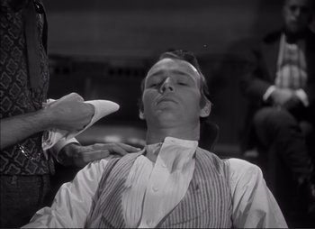 A man getting his tie adjusted by another man