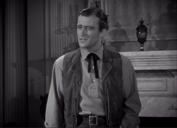 Movie still from “Dark Command” (1940), directed by Raoul Walsh – A black and white photo of a man in a suit and tie; Medium shot, Low angle