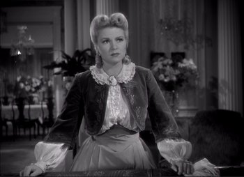 Movie still from “Dark Command” (1940), directed by Raoul Walsh – An old photo of a woman in a victorian dress; Medium shot, Over the shoulder angle