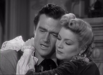 Movie still from “Dark Command” (1940), directed by Raoul Walsh – A man and a woman embracing each other in a black and white photo; Close Up shot, Low angle