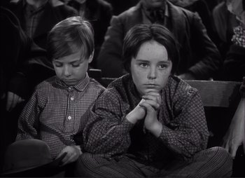 Movie still from “Dark Command” (1940), directed by Raoul Walsh – Two young boys sitting in a row in a church; Medium shot, High angle