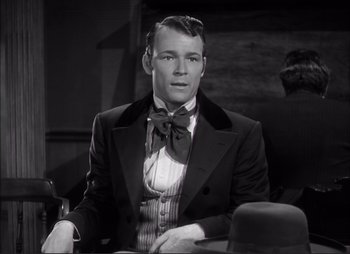 Movie still from “Dark Command” (1940), directed by Raoul Walsh – A black and white photo of a man in a suit and bow tie; Medium shot, Over the shoulder angle