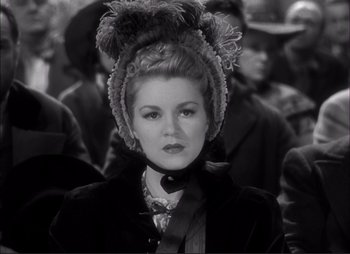 Movie still from “Dark Command” (1940), directed by Raoul Walsh – A black and white photo of a woman in a fur hat; Close Up shot, Over the shoulder angle