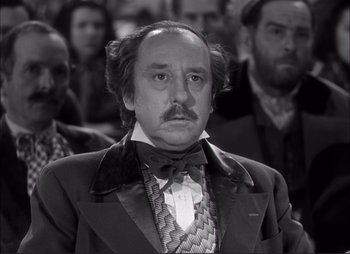 Movie still from “Dark Command” (1940), directed by Raoul Walsh – A man in a suit and tie with a mustache; Close Up shot, Low angle