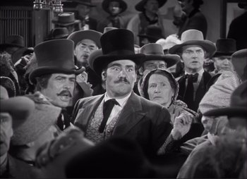 Movie still from “Dark Command” (1940), directed by Raoul Walsh – A black and white photo of a group of people wearing hats; Medium shot, Low angle
