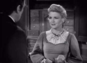 Movie still from “Dark Command” (1940), directed by Raoul Walsh – An old photo of a man and a woman talking to each other; Medium shot, Over the shoulder angle