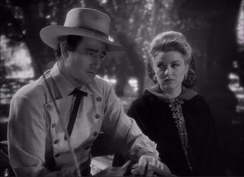 Movie still from “Dark Command” (1940), directed by Raoul Walsh – A man and a woman are sitting next to each other; Medium shot, Over the shoulder angle