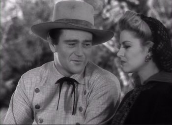 Movie still from “Dark Command” (1940), directed by Raoul Walsh – A man and a woman are looking at one another; Medium shot, Low angle