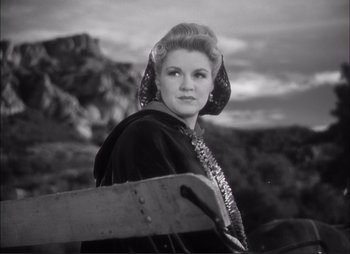Movie still from “Dark Command” (1940), directed by Raoul Walsh – A black and white photo of a woman holding a snowboard; Close Up shot, Low angle