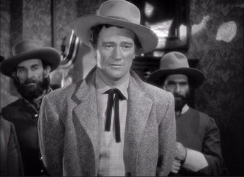 Movie still from “Dark Command” (1940), directed by Raoul Walsh – A black and white photo of a man in a suit and hat; Medium shot, Low angle