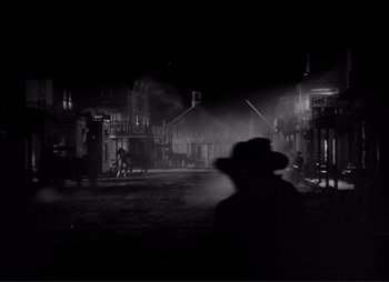 Movie still from “Dark Command” (1940), directed by Raoul Walsh – A black and white photo of a town at night; Wide shot, Low angle