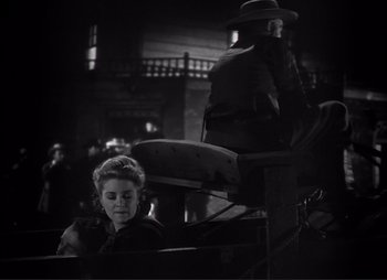 Movie still from “Dark Command” (1940), directed by Raoul Walsh – An old photo of a woman and a man sitting in a carriage; Medium shot, Low angle