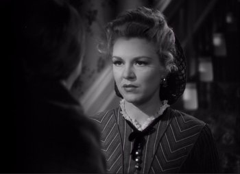 Movie still from “Dark Command” (1940), directed by Raoul Walsh – A black - and - white photo of a woman looking at the camera; Close Up shot, Over the shoulder angle