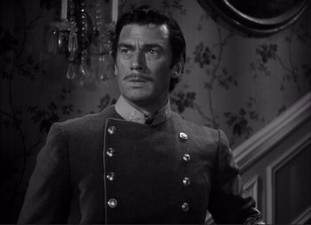 Movie still from “Dark Command” (1940), directed by Raoul Walsh – A black and white photo of a man in a military uniform; Close Up shot, Over the shoulder angle