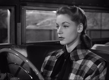 Movie still from “Dark Passage” (1947), directed by Delmer Daves – A black and white photo of a woman in a plaid jacket; Close Up shot, Low angle