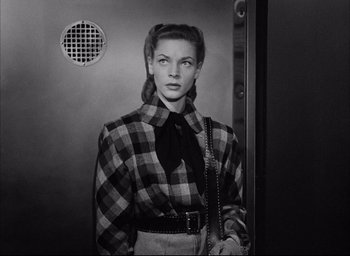 Movie still from “Dark Passage” (1947), directed by Delmer Daves – A black and white photo of a woman in a checkered shirt; Medium shot, Low angle