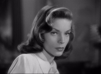 Movie still from “Dark Passage” (1947), directed by Delmer Daves – A black - and - white photo of a woman in a white shirt; Close Up shot, Low angle