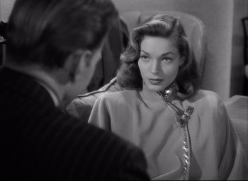 Movie still from “Dark Passage” (1947), directed by Delmer Daves – A woman sitting in a chair talking to a man; Close Up shot, Over the shoulder angle