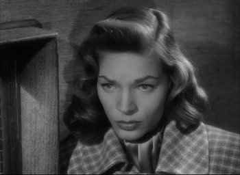 Movie still from “Dark Passage” (1947), directed by Delmer Daves – A black - and - white photo of a woman in a checkered jacket; Close Up shot, Low angle